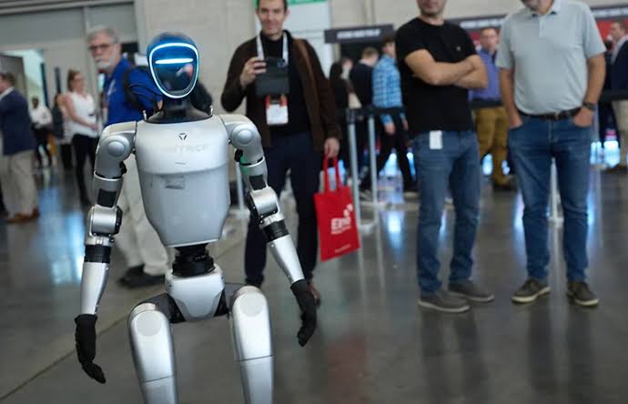 Humanoid robot greeting a crowd at an expo